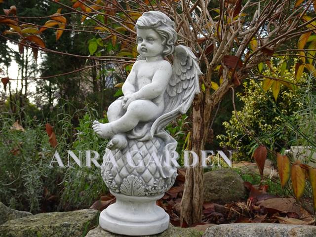 A figure of an angel sitting on a ball